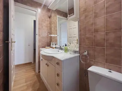a bathroom with a sink and a mirror and a tub at Hauzify I Apartament Can Reig in San Pol de Mar