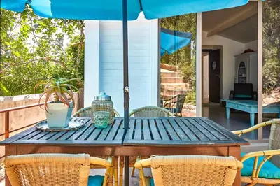 a table with chairs and an umbrella on a patio at Sitges Hill Retreats-Masia Nur 22 bedrooms divided over 9 houses for max 44 guests in Canyelles