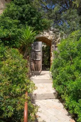 a stone path leading to a door in a garden at Sitges Hill Retreats-Masia Nur 22 bedrooms divided over 9 houses for max 44 guests in Canyelles