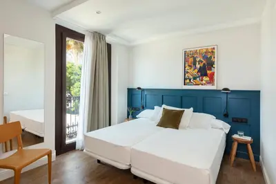 a bedroom with a large bed with a blue headboard at Som Nit Port Vell in Barcelona