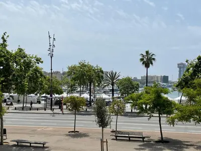 a park with benches and trees on a street at Som Nit Port Vell in Barcelona