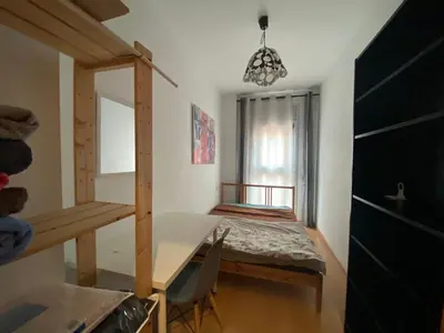 a small room with a table and a bed at Oasis familiar Terrassa in Terrassa