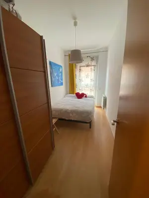 a bedroom with a bed and a door to a room at Oasis familiar Terrassa in Terrassa