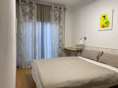 a bedroom with a large bed and a window at Oasis familiar Terrassa in Terrassa