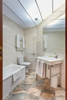 a bathroom with a tub and a sink and a toilet at Alba Hotel in Barcelona