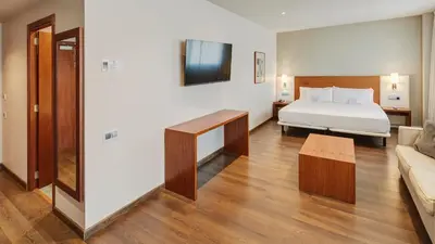 a hotel room with a bed and a couch at Sercotel Ciutat de Montcada in Montcada i Reixac