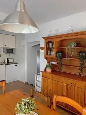 a kitchen and dining room with a large wooden cabinet at Refugio en el Parque natural del Montseny in El Brull