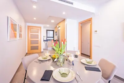a dining room with a white table and chairs at Sweett - Casa Fira in Barcelona