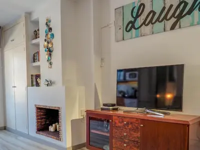 a living room with a tv and a fireplace at The Beach Studio by Hello Homes Sitges in Sitges