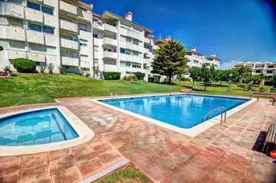 a swimming pool in front of a large apartment building at The Beach Studio by Hello Homes Sitges in Sitges