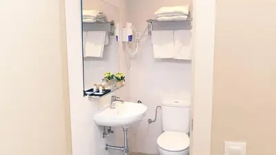 a bathroom with a toilet and a sink and towels at Hotel Coronado in Barcelona
