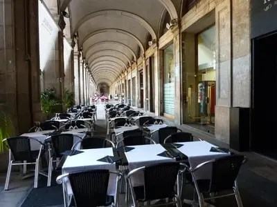 an empty hallway with tables and chairs in a building at Roma Reial in Barcelona