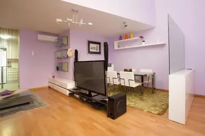 a living room with a tv and a dining room at Vale Beach in Barcelona