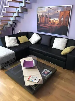 a living room with a black couch and a glass table at Vale Beach in Barcelona