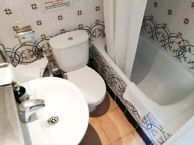 a bathroom with a toilet and a sink and a tub at Casa Consell Gran Via, Guest House in Barcelona