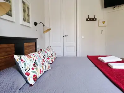 a bedroom with a bed with a red blanket at Casa Consell Gran Via, Guest House in Barcelona