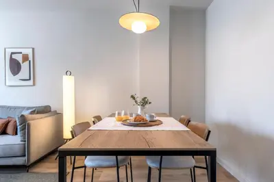 a dining room with a wooden table and chairs at Arrivo Apartments in Barcelona