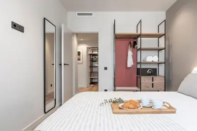a bedroom with a bed with a tray of bread on it at Arrivo Apartments in Barcelona