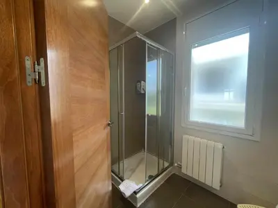 a glass shower in a bathroom with a window at Villa Farell just in front of the sea in San Pol de Mar