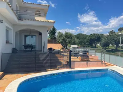 a swimming pool in front of a house at Villa Farell just in front of the sea in San Pol de Mar