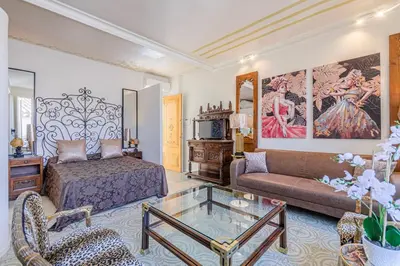 a bedroom with a bed and a couch and a table at El Petit Palauet in Canet de Mar