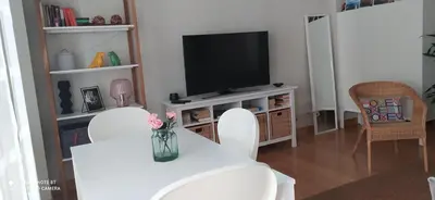 a living room with a white table and a television at Studio doria in Sant Boi del Llobregat