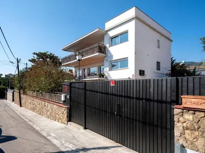 a black fence in front of a white house at Apartment Millenium by Interhome in Premia de Dalt
