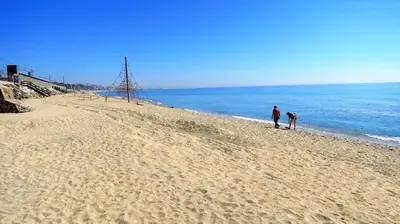 two people walking on a beach near the water at EMILY BEACH-CITY Apartment in Montgat