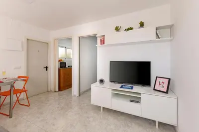 a white living room with a flat screen tv at Barcelona Sunny Terrace in Hospitalet de Llobregat