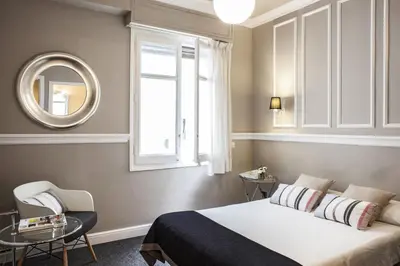 a bedroom with a bed and a window and a mirror at AinB B&B Eixample-Muntaner in Barcelona