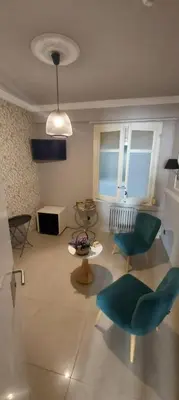 a living room with a green chair and a table at AinB B&B Eixample-Muntaner in Barcelona