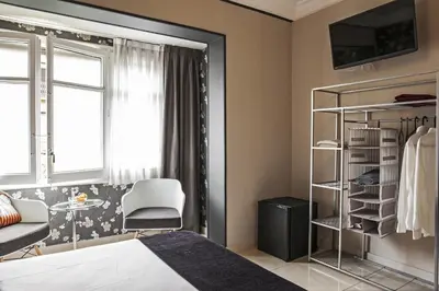 a bedroom with a bed and a chair and a window at AinB B&B Eixample-Muntaner in Barcelona