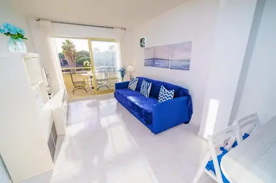 a living room with a blue couch and a balcony at HomeHolidaysRentals Cyan- Costa Barcelona in Pineda de Mar