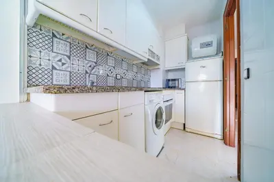 a white kitchen with a washer and dryer in it at HomeHolidaysRentals Cyan- Costa Barcelona in Pineda de Mar