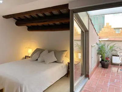 a bedroom with a bed and a large window at SF Apartamento céntrico con terraza in Terrassa