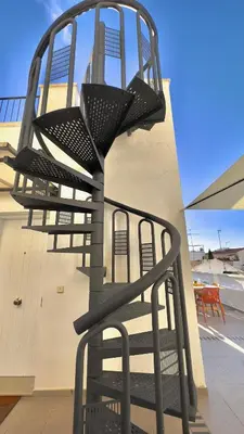 a black chair sitting on the side of a building at Penthouse in Historic Sitges -Big Terrace & Private Solarium in Sitges