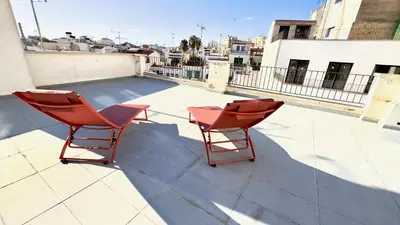 two red chairs sitting on top of a roof at Penthouse in Historic Sitges -Big Terrace & Private Solarium in Sitges