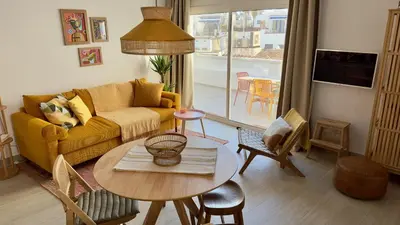 a living room with a yellow couch and a table at Penthouse in Historic Sitges -Big Terrace & Private Solarium in Sitges