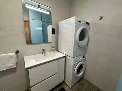 a bathroom with a washing machine and a sink at Casa L'Avi in Palau-Solità i Plegamans