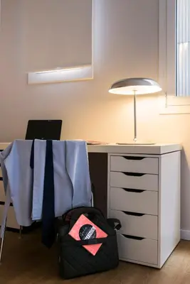 a desk with a bag next to a desk with a lamp at Bed&BCN Diagonal 4 in Barcelona