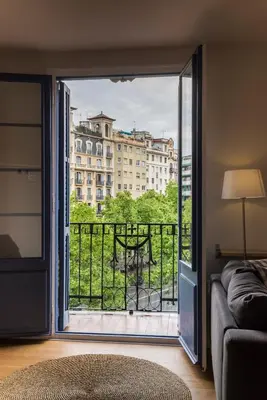a living room with a view of a balcony at Bed&BCN Diagonal 5 in Barcelona