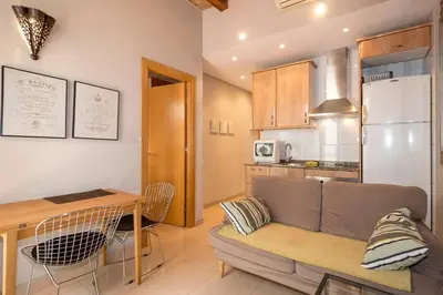 a living room with a couch and a table and a kitchen at BeBarceloner Gracia Apartments- 1 bedroom in Barcelona