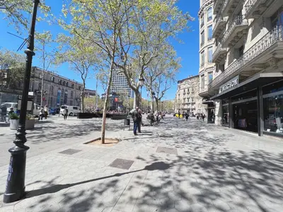 a city street with people walking on the sidewalk at Stay U-nique Apartment Passeig de Gràcia III in Barcelona