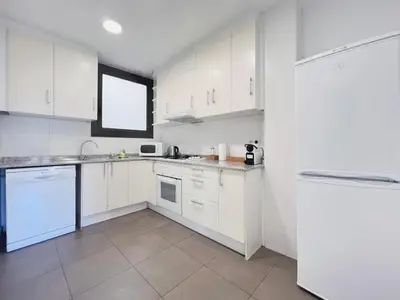 a white kitchen with white cabinets and a window at Stay U-nique Apartment Passeig de Gràcia III in Barcelona