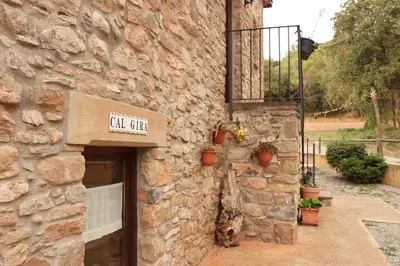 a stone building with a sign that reads call center at Mas Cal Gira in Moià