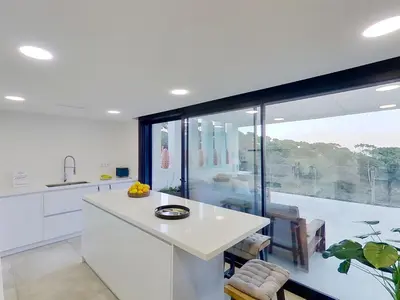 a kitchen with a white counter and a large window at Premium Habitat 3 Hermanas in Sant Andreu de Llavaneres