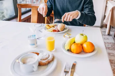 a person sitting at a table with plates of breakfast food at Can Fisa Hotel & Apartments in Corbera de Llobregat