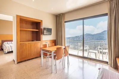 a room with a table and chairs and a large window at Can Fisa Hotel & Apartments in Corbera de Llobregat