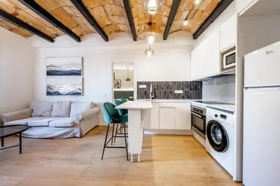 a kitchen and living room with a couch and a table at BeBarceloner Eixample Apartments - 4 bedrooms in Barcelona