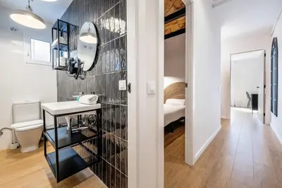 a bedroom with a white bed and a hallway at BeBarceloner Eixample Apartments - 4 bedrooms in Barcelona